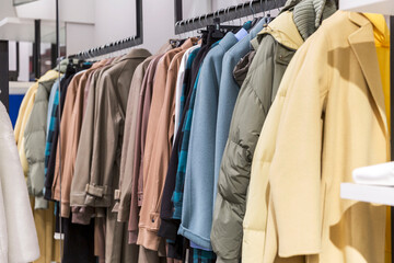 Obraz premium Top women's autumn-winter clothes on a hanger in a store. Fashion & Style.