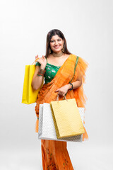 Young Indian women wearing saree outfit and holding shopping bags.on white background.