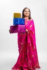 Indian older woman in traditional saree and holding gift box in hand