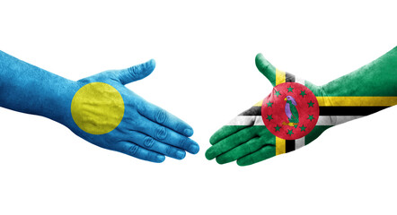 Handshake between Dominica and Palau flags painted on hands, isolated transparent image.