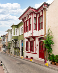 Fototapeta na wymiar Cobblestone alley, with beautiful old colorful traditional wooden houses on the side, suited in Fatih district, Istanbul, Turkey, in a summer day