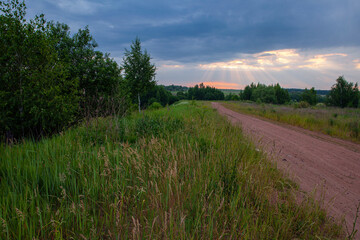 Panoramic shot of a country road leading into the dawn sky