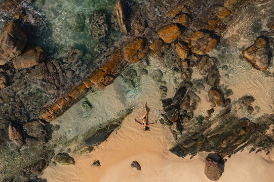 Top Aerial View of Tanned Woman in Bikini on the Rocky Beach on Summer