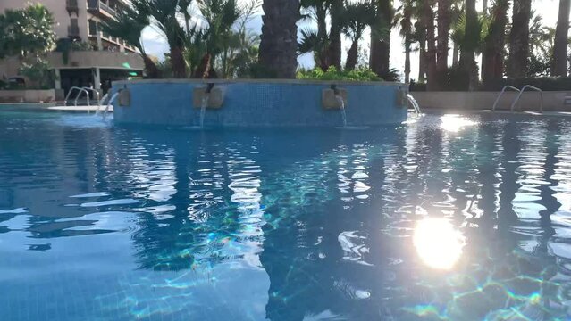 12.05.2022 Cyprus Paphos Elysium hotel Clear blue water in a hotel swimming pool, hotel swimming pool, close shot. Sun in water