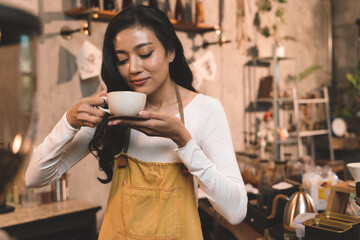 portrait of waitress handing and sip a coffee and present coffee with smiling. the happiness woman in coffee shop on waitress uniform and service customer.