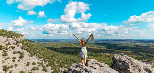 Woman tourist on mountain peak enjoying panoramic view of valley ( languedoc in France) - obrazy, fototapety, plakaty