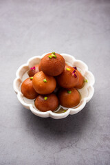 Gulab jamun or gulabjamun is an Indian sweet, served in a bowl as pile. closeup view