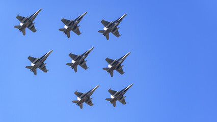 Group of supersonic aircraft in formation, flying close together in an aerial military parade.