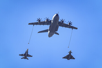 Supersonic fighter refueling aircraft in the air to fuel smaller aircraft.