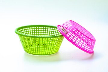 Bright colored plastic baskets on a white background.