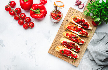 Crispy bruschetta with soft goat cheese and sweet red paprika in olive oil with herbs served on...