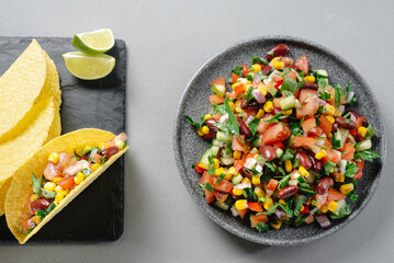 Texas caviar. Vegetarian salad on a gray plate top view on a gray background. Mexican Tacos with...