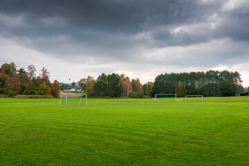 Fototapeta premium A football (soccer) training ground in a rural autumn landscape. Perfectly trimmed lush green grass. .A beautifully situated football field. Polanka Wielka, Poland