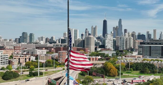 Flying around waiving American flag with Chicago skyline and downtown expressway in background. Aerial view