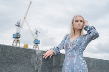 Woman in blue dress enjoys sea shore.