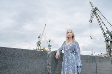 Woman in blue dress enjoys sea shore.