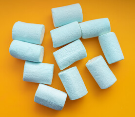Blue marshmallows on orange background.