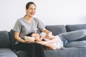 Two young asian woman couple living together on sofa at home or apartment