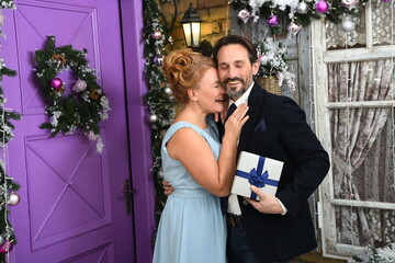 Lovely mature couple feeling happy together. Stylish woman keeping her eyes closed and laughing sincerely while tenderly embracing her elegant husband