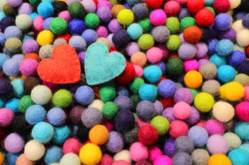 Background of balls of carved wool and two blue and red hearts