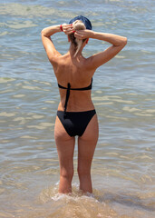 Girl in a black swimsuit on the beach
