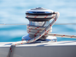 Close up of a winch with a line on against a blue background