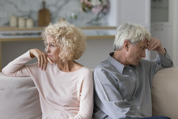 Unsuccessful relationships, failed marriage, relations break up, misunderstanding. Silent sad older married couple sit on sofa separately ponder over problems feel dissatisfied, thinking about divorce - obrazy, fototapety, plakaty