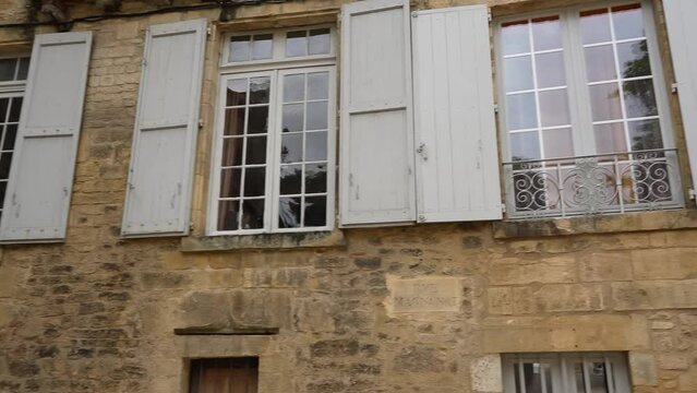 panorama of French georgian era windows with white painted wooden shutters 