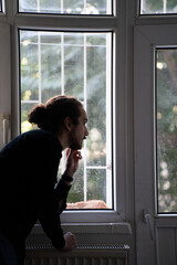 Fototapeta premium sad person watching outside from window