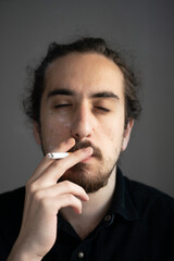 sad man smoking cigarette at home