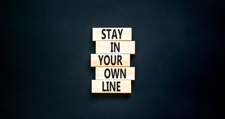 Stay in your own line symbol. Concept words Stay in your own line on wooden blocks. Beautiful black table black background. Business and stay in your own line concept. Copy space.