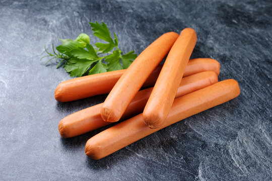 Traditionelle rohe deutsche Bockwurst angeboten als close-upt auf grauem Board mit Textfreiraum