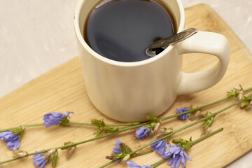 a mug with a drink and chicory flowers on a cutting board