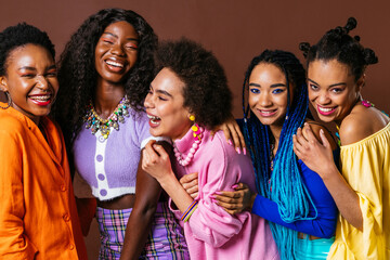 Group of Beautiful black women posing in studio on colored background with colorful fashionable clothes style