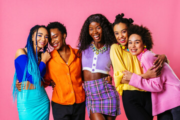 Group of Beautiful black women posing in studio on colored background with colorful fashionable...