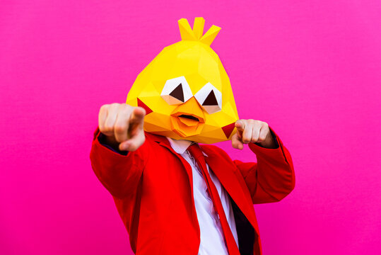 Cool man wearing  funny 3d origami mask and costume on colorful background