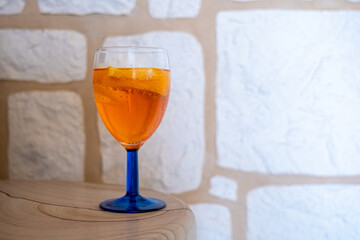 glass of alcoholic beverage in front of a stone wall