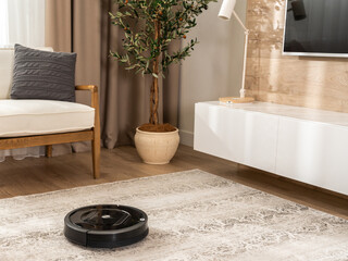 A corner in a modern living room in which a robot vacuum cleaner cleans