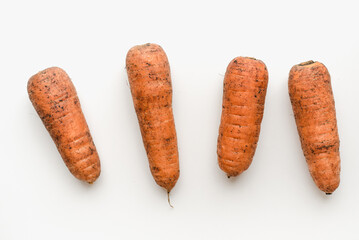 Carrots on a white background. Dirty carrot.