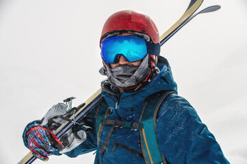 Fototapeta na wymiar Young man on a ski vacation in the mountains, portrait. Great rider holiday in ski resort