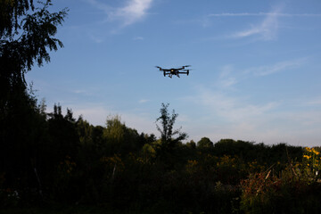 Fototapeta na wymiar Drone in sky. Drone flight over forest. Air vehicle.