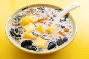 angle view bowl of milk tea flavor syrup with mango and sweet potato and sago and black jelly