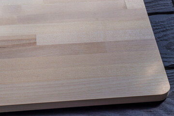 Wooden cutting board. Made of glued birch parts. Close-up. Cutting board detail. Crafted of birch