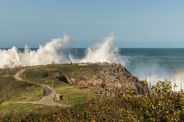 Fototapeta na wymiar Big waves breaking against the cliffs. Huge waves in the coast during a sea storm. Maritime storm.
