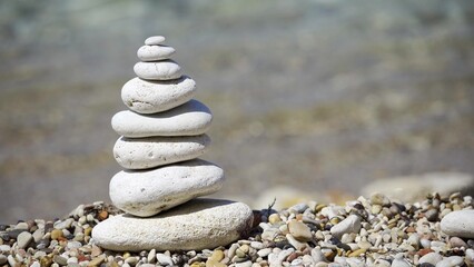 Fototapeta na wymiar Zen meditation background - balanced stones stack cairn close up on sea beach.