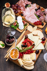 Food antipasto white wine or Prosecco and prosciutto ham, salami, olives and grissini bread sticks. cheese on a board parmesan, pecorino, gorgonzola. Charcuterie board. 