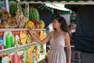 Tourist woman buying a freshly made juice of fresh fruit in the Jmaa El Fna square in the Moroccan city of Marrakech, this juice is very fresh and they make it to your liking in this square in Morocco