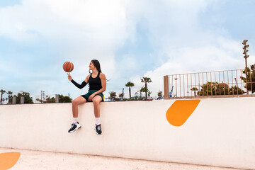 General plane of a basketball player spinning a basketball on her finger sit on the wall. Enjoy the...