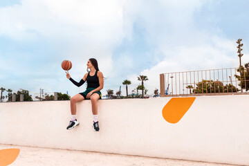 General plane of a basketball player spinning a basketball on her finger sit on the wall. Enjoy the free time