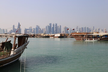Naklejka premium Cityscape with old boats on skyscrapers from the Corniche in Doha, Qatar